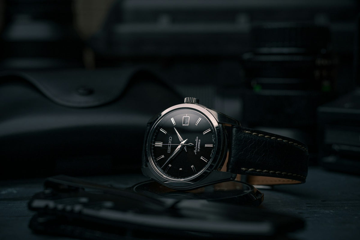 Reloj de esfera negra con caja plateada y correa de piel negra
